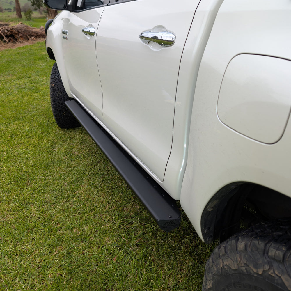 Trig Point n80 n90 hilux side steps installed on muddy white Toyota 