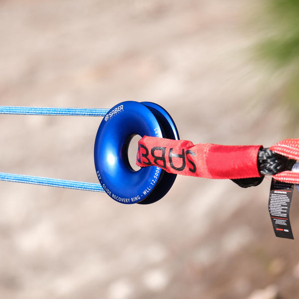 Saber Offroad Ezy-Glide Recovery Ring in blue finish displayed in the outdoors in use with recovery rope